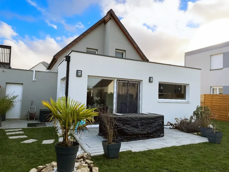 Maison contemporaine avec extension moderne à toit plat, terrasse carrelée et jardin paysagé