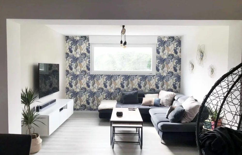 Maison contemporaine avec extension moderne à toit plat et bardage bois, située dans jardin paysagé avec piscine