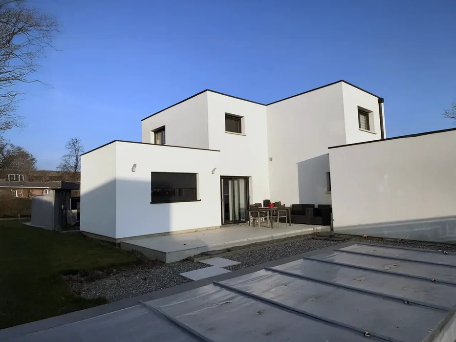 Maison contemporaine avec extension moderne en bardage bois vertical sur terrain paysager