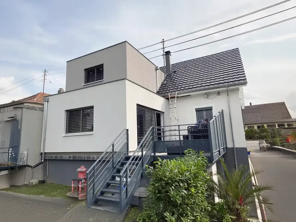 Intérieur moderne avec grande baie vitrée donnant sur forêt verdoyante